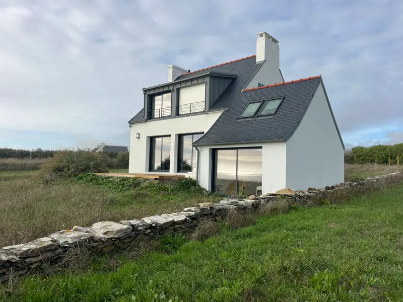 Maison bretonne contemporaine avec terrasse en bois, dont la ventilation est contrôlée selon la RE2020