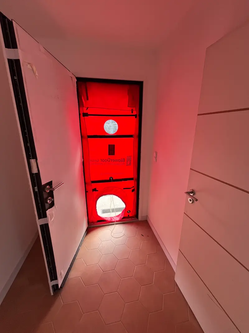 Porte soufflante installée dans l'entrée d'une maison neuve pour un test d'étanchéité à l'air dans le Finistère
